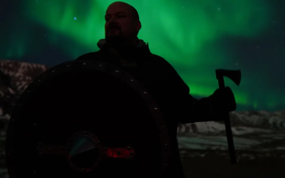 A person photographing the aurora in the dark