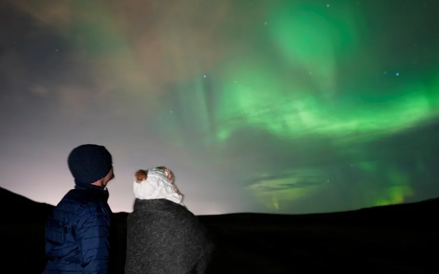 A guide photographing the aurora for a small group